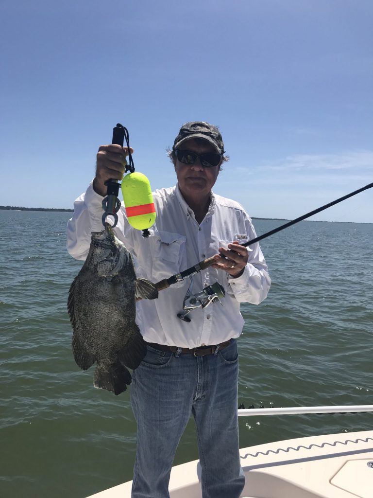 Man holding a triple tail caught on the charter