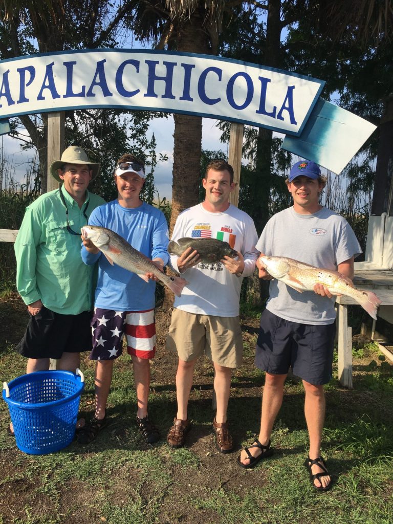 Group photo holding the catches from the charter